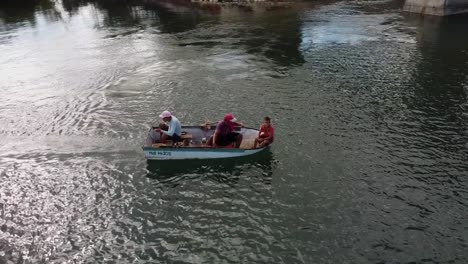 Aerial-orbit-shot-of-fishermen-in-small-boat-fishing-in-river-of-Venezuela-during-golden-sunrise