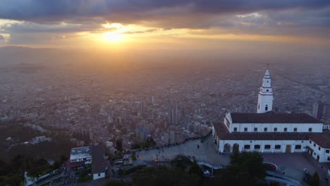 Drone-shot-of-Monserrate-church-overlooking-the-city-of-Bogota,-Colombia-at-sunset