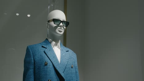 Maniquí-Con-Un-Elegante-Traje-Azul-Y-Gafas-De-Sol-Expuestas-En-Una-Boutique