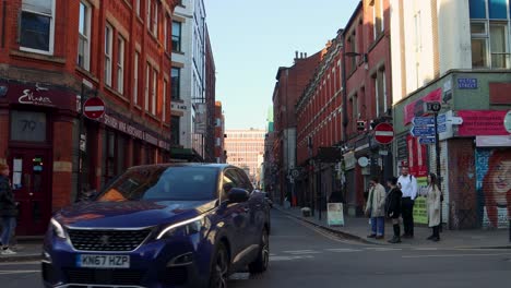 Straßenszene-Im-Northern-Quarter-In-Manchester-Mit-Menschen,-Geschäften-Und-Autos-An-Einem-Sonnigen-Tag