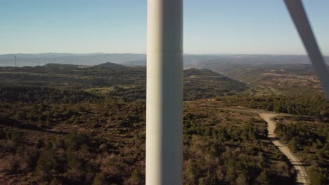 Una-Turbina-Eólica-En-Igualada,-Barcelona,-Con-Colinas-Pintorescas-Y-Cielos-Despejados