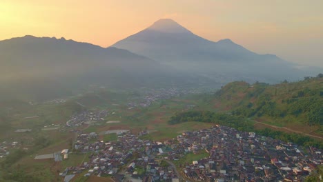 Panorama-Aéreo-Del-Monte-Sindoro-Al-Atardecer,-Pueblo-Kejajar-Y-Wonsobo-En-Indonesia