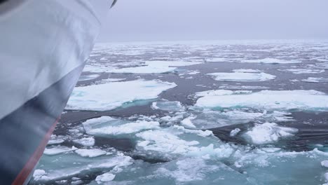 Bow-of-Boat-Sailing-Between-Broken-Pieces-of-Ice-in-Cold-Arctic-Sea,-Slow-Motion