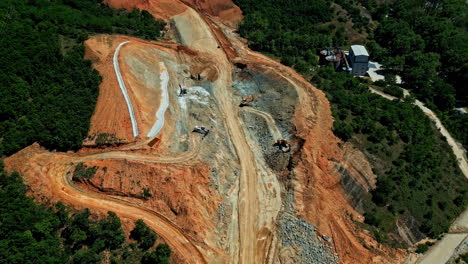 Excavadora-En-Un-Gran-Sitio-De-Construcción-De-Una-Nueva-Carretera-A-Través-De-Un-Denso-Bosque-Verde