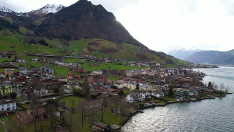 Vista-Aérea-Del-Pueblo-Beckenried-Bajo-Los-Alpes-Suizos-En-La-Costa-Del-Lago-De-Lucerna,-Disparo-De-Drones