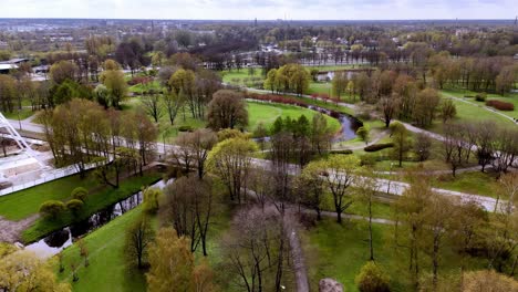 Riga,-Letonia,-Europa---Un-Ambiente-Sereno-Y-Acogedor-En-El-Parque-Uzvaras---Toma-Aérea-De-Retroceso