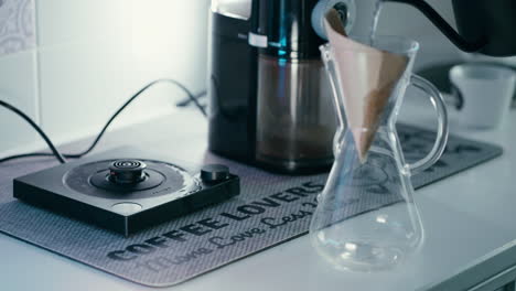 Taking-a-Barista-water-Kettle-and-pouring-over-Paper-Filter-in-Chemex,-making-it-wet-before-making-Coffee