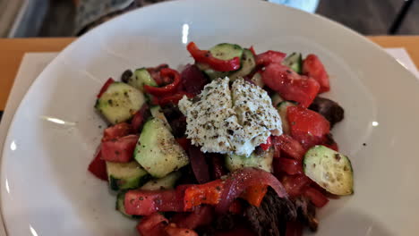 Junge-Frau-Mit-Braunen-Haaren-Genießt-Griechischen-Salat-Im-Modernen-Restaurant