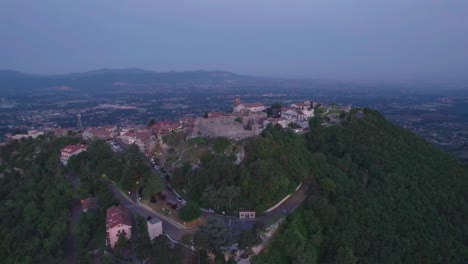 órbita-Aérea-Del-Pequeño-Pueblo-En-La-Cima-De-La-Montaña-Al-Amanecer,-Italia