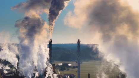 Plumes-of-greenhouse-gases-emitted-from-industrial-factory-chimneys,-aerial-view