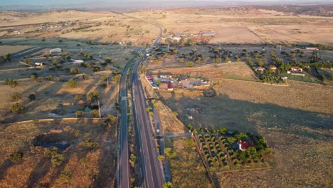 Pozoblanco-town-at-sunrise,-showcasing-roads-and-rural-landscape,-aerial-view