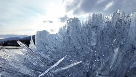 Vea-Un-Primer-Plano-De-Múltiples-Cristales-De-Hielo-Formándose-Y-Brillando-Bajo-La-Luz.