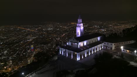 Toma-De-Drone-De-La-Iglesia-De-Monserrate-Con-Vistas-A-La-Ciudad-De-Bogotá,-Colombia-Por-La-Noche.