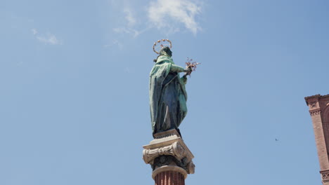 Majestuosa-Estatua-De-Un-Santo-Con-Halo-Contra-El-Cielo-Azul-En-Bolonia