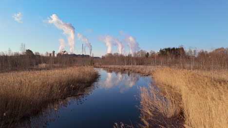 Yuxtaposición-Del-Ecosistema-Fluvial-Natural-Cerca-De-Una-Fábrica-Que-Emite-Gases-Tóxicos