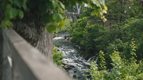 Malerische-Aussicht-Auf-Den-Fluss-Slunjčica,-Der-Durch-üppiges-Grün-Fließt,-Mit-Einer-Rustikalen-Brücke-In-Rastoke,-Kroatien