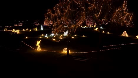 Aerial-footage-panning-to-the-left-reveals-a-park-turned-into-a-enchanting-winter-wonderland,-adorned-with-countless-sparkling-Christmas-lights