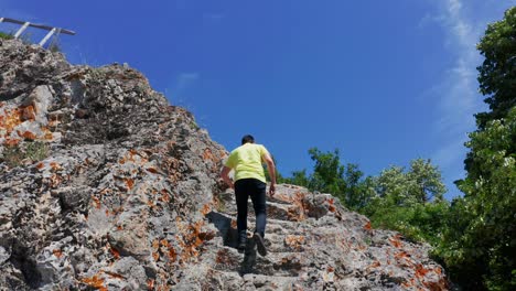 Man-Climbing-Stone-Steps-In-Granite-Rock-At-Ancient-Thracian-Occult-Place-Of-Deaf-Stones-In-Rhodope-Mountains,-Bulgaria