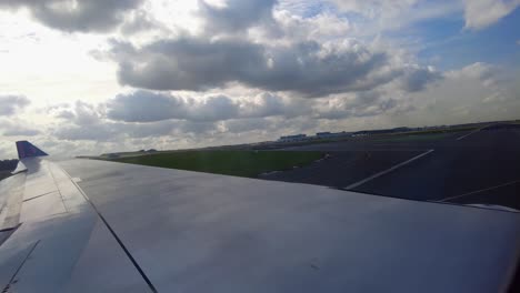 Taxiing-airplane-turning-on-runway-for-takeoff-at-Brussels-airport,-Belgium-with-visible-control-tower-viewed-from-inside-aircraft