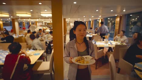 Asian-woman-carrying-buffet-plate-in-cruise-dining-room
