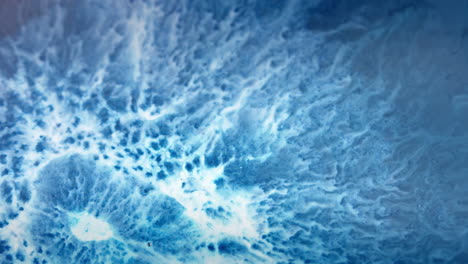 Vibrant-blue-and-white-ink-swirling-in-water-creating-mesmerizing-abstract-patterns