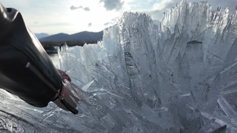 Persona-Que-Toca-Formaciones-De-Hielo-Grandes-E-Intrincadas-Con-La-Luz-Del-Sol-De-La-Tarde-Iluminando-La-Escena-En-Una-Zona-Montañosa