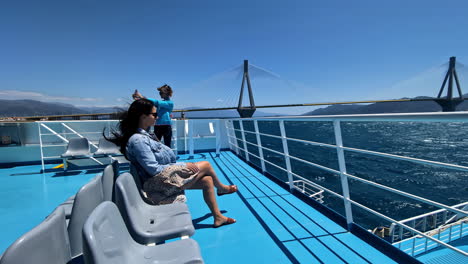 Mujer-Disfrutando-De-Un-Viaje-En-Ferry-Pasando-El-Puente-Río-Antirrio