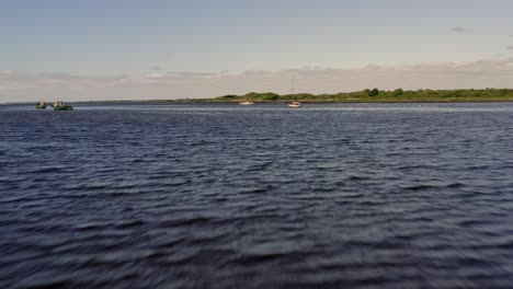 Fast-aerial-tracking-shot-close-to-the-water-in-Kinvara-Bay,-Galway