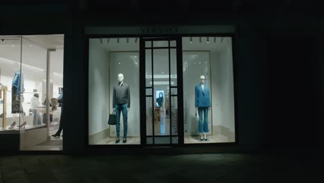 Escaparate-De-Versace-Con-Maniquíes-Con-Trajes-Elegantes,-Iluminado-Por-La-Noche-En-Venecia