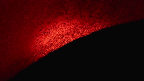 Dark-moody-scene-of-a-black-particles-against-red-background