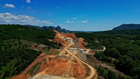 Construction-site-scenic-countryside,-building-new-highway-through-nature,-aerial