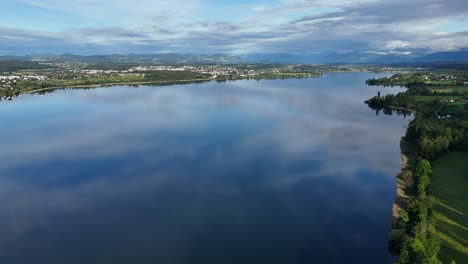Calm-water-surface-of-Greifensee-lake-with-sky-reflection,-Switzerland