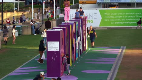 Los-Turistas-Se-Divierten-Tomando-Fotos-Con-El-Emblemático-Monumento-Y-Los-Niños-Subiendo-Y-Bajando-El-Cartel-De-La-Ciudad-De-Brisbane-En-Un-Día-Soleado,-Queensland,-Australia