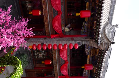 Qing-Dynasty-girl-with-hand-fan-walking-through-a-traditional-Chinese-house,-Pingyao