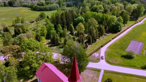 Letonia,-Europa---Iglesia-Evangélica-Luterana-De-Skujene-En-El-Día-De-Verano---Drone-Volando-Hacia-Adelante