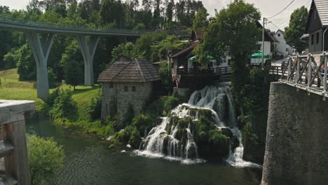 Encantadores-Edificios-De-Piedra-Y-Madera-Con-Una-Pintoresca-Cascada-Y-Un-Puente-En-Rastoke,-Croacia