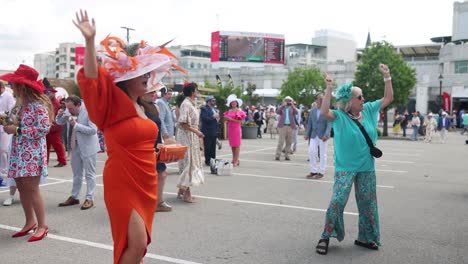 Dos-Mujeres-Bailando-Alegremente-En-Una-Fiesta-En-Churchill-Downs,-Celebrando-Antes-Del-150º-Derby-De-Kentucky