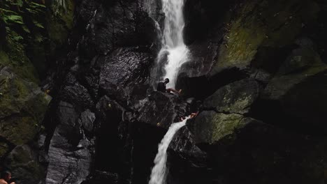 Rocky-waterfall,-splashing-frothy-water,-kids-unwinding-leisure-time