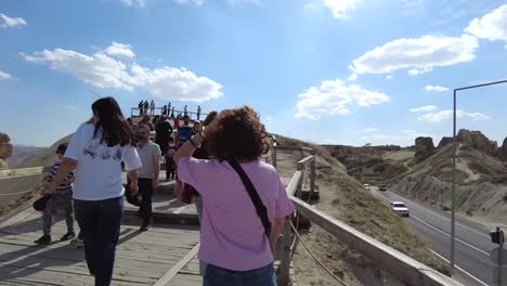 Slow-motion-shot-of-a-woman-walking-from-behind-in-a-tourist-area-with-other-people-on-a-sunny-day-in-Cappadocia-Turkey