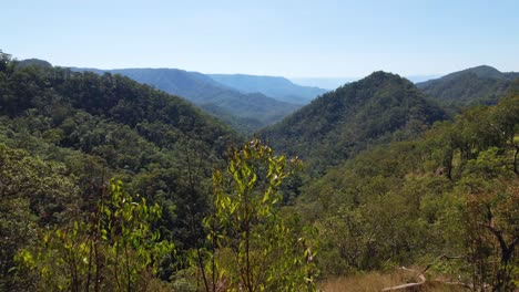 4K-Drone-Nature-Video-flying-forwards-with-a-couple-looking-at-the-Queensland-Australia-Landscapes-of-lush-green-rainforest-and-beautiful-mountains