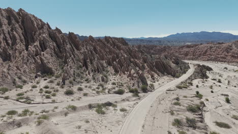 Schotterstraße-Ruta-40,-Die-Durch-Die-Atemberaubende-Geologische-Formation-Quebrada-De-Las-Flechas-Führt