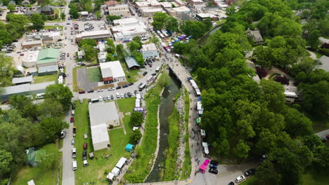 Dogwood-festival-celebration-in-arkansas-with-colorful-booths-and-a-lively-crowd,-aerial-view