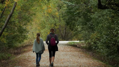 Mother-and-daughter-on-a-nature-hike-in-the-forest-in-autumn