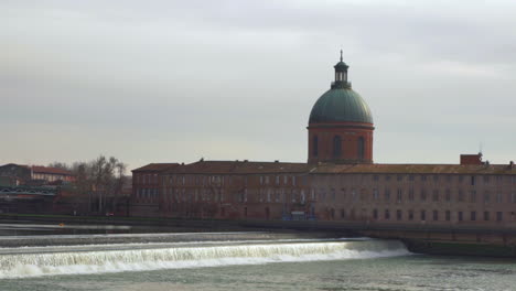 This-shot-depicts-a-12th-Century-Hopital-De-La-Grace-in-Toulouse,-France-surrounded-by-the-calmness-of-the-weir