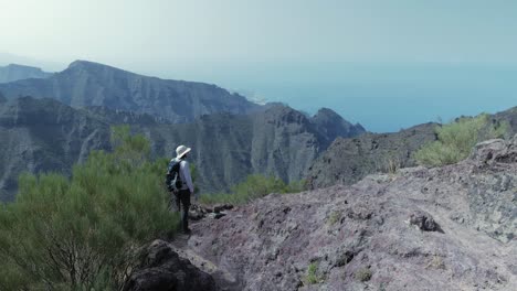 Female-hiker-in-Teno-mountains,-Tenerife,-enjoying-the-panoramic-view-over-the-ocean