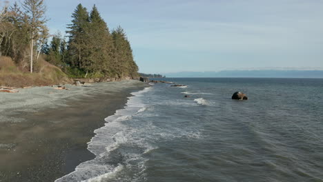 Drone-over-a-beach-and-trees-on-Vancouver-Island-in-Sooke,-British-Columbia-Canada