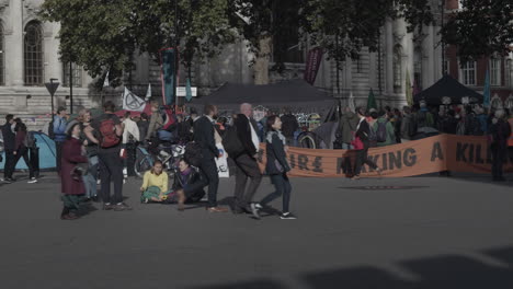 Two-women-demonstrators-sitting-outside-the-west-entrance-of-Westminster-Abbey-at-an-Extinction-Rebellion-demonstration