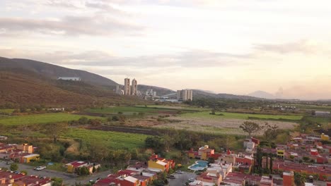 Drone-Aéreo-Disparado-En-México-Morelos-Con-Industria-Del-Hormigón-Cerca-De-Algunas-Casas-Al-Atardecer-Y-Montaña-Verde
