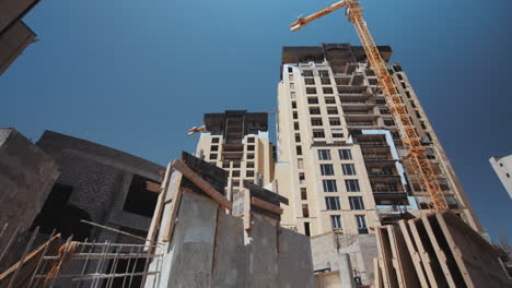 Constructions,-Compound-2-clips-of-a-construction-site,-Wide-shot-side-Dolly-right,-wide-shot-pan-right,-construction-building-with-crane,-sunny-summer-day,-4K-footage