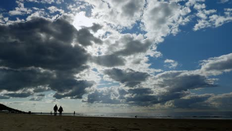 People-walking-on-the-Baltic-sea-beach-during-the-cloudy-day